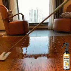 a room with wooden floors and furniture in the background, there is a bottle of cleaner on the floor