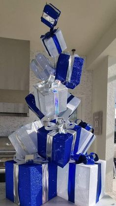 blue and white presents stacked on top of each other in the middle of a room