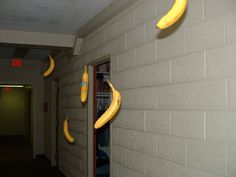 some bananas hanging from the side of a wall in front of a hallway with a door