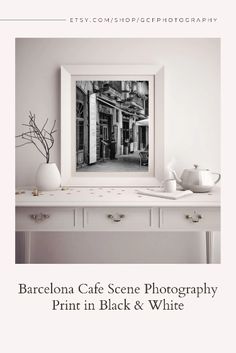 an image of a black and white photograph on the wall above a table with two cups