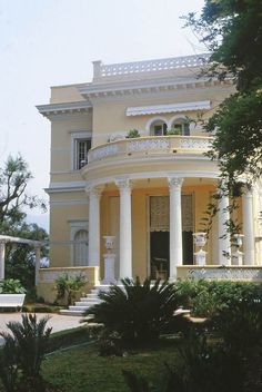 a large yellow house with columns on the front