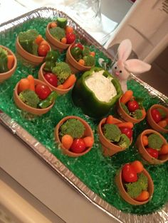 a tray filled with lots of vegetables on top of a counter next to a bunny