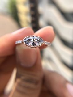 a person holding an engagement ring in their hand with the diamond on it's side