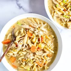 two bowls of chicken noodle soup on a table