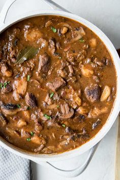 a white bowl filled with meat and mushroom stew