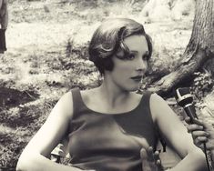 a woman sitting in a chair holding two microphones