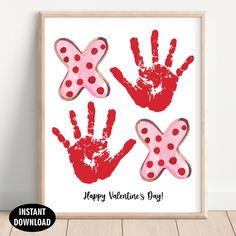 two handprints with red and pink polka dots are displayed in a wooden frame