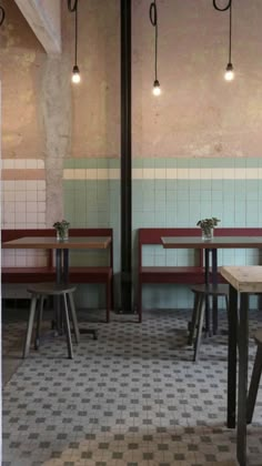 an empty restaurant with checkered flooring and tables in front of the wall that has been painted pink