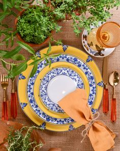 a place setting with yellow and blue plates