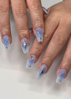 a woman's hands with blue and white nail designs on their fingertipss,