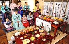 a group of people standing next to each other in front of a table with food on it