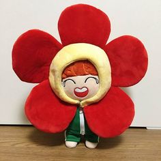 a red flower shaped stuffed animal with a smiling face on it's back end