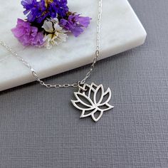 ✦This beautiful lotus flower necklace makes a perfect gift for her. The lotus pendant is made from solid 925 sterling silver. It comes in two sizes, a smaller  15mm x 15mm (~ 1/2 inch) pendant, and a larger size that measures 19mm x 19mm (~3/4 inch). ✦The pendant hangs from a jump ring on a sterling silver cable chain in lengths of 16, 18 or 20 inches. Closes with a spring clasp and loop. Custom or longer lengths available on request - please contact seller. ✦Also available in gold https://www.etsy.com/listing/576087846 and rose gold https://www.etsy.com/listing/493606328 ✦Lotus Flower Symbolism The lotus flower is a symbol of clarity. It grows in muddy water, rising and blooming above the murkiness.  ✦Your jewelry will be packaged in a beautiful and reusable organza bag. All items will be Minimalist Sterling Silver Flower Shaped Necklaces, Minimalist Silver Necklace For Meditation, Delicate Silver Necklace For Meditation, Silver Elegant Charm Necklace For Meditation, Elegant Silver Charm Necklace For Meditation, Holistic Silver Necklace With Flower Pendant, Spiritual Sterling Silver Necklace With Flower Charm, Lotus Flower Symbolism, Sterling Silver Spiritual Necklace With Flower Charm