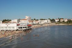 people are on the beach and in the water at this city's seasideside