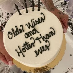 a person holding a cake with writing on it