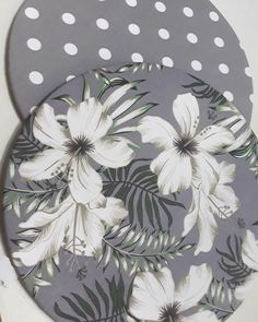 two plates with white flowers on them are sitting on a counter top next to polka dots