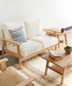 a living room filled with furniture next to a white couch and coffee table on top of a rug