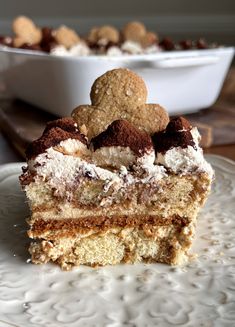 a piece of cake sitting on top of a white plate next to a bowl of cookies