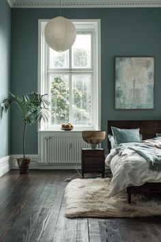 a bedroom with blue walls and wooden floors, a bed in the foreground has a white rug on top of it