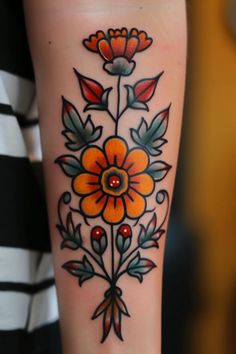 a woman's arm with an orange flower tattoo on it