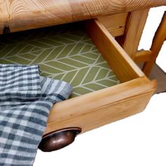 a close up of a wooden chair with a plaid cloth under the armrests