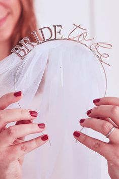 two hands are holding a bride's tiara with the word bride on it