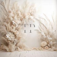 a white backdrop with flowers and feathers