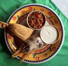 corn on the cob, rice and other foods are sitting on a colorful plate