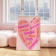 a pink heart - shaped poster with words written on it in front of a window