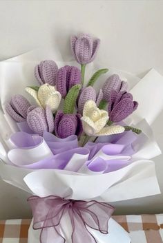 a bouquet of crocheted flowers sitting on top of a checkered table cloth