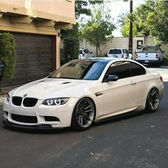 a white car parked in front of a garage