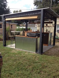 an outdoor kitchen made out of shipping containers in the grass with a grill on top