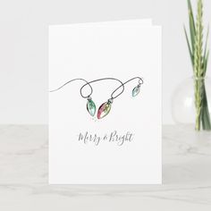 a christmas card with three lights hanging from it's string and the words merry and bright