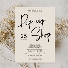 a poster with the words pop up shop on it next to some dried plants and flowers