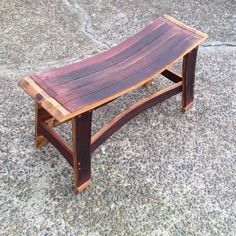 a wooden bench sitting on top of a cement floor next to a sidewalk with no people