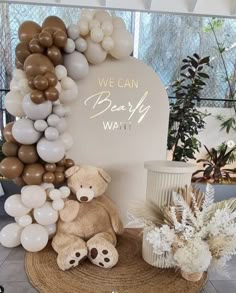 a teddy bear sitting on top of a rug next to some balloons and other decorations