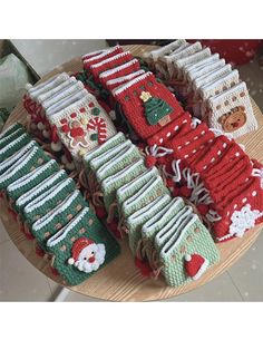 knitted christmas stocking samples on a wooden table with santa's stockings and snowmen