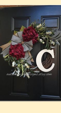 a wreath with flowers on the front door