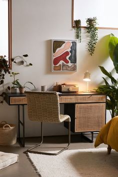 a room with a desk, chair and potted plants