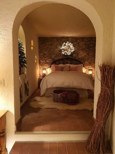 a bed in a room with a stone wall and brick flooring next to a doorway