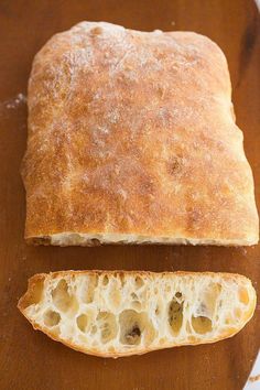 a loaf of bread sitting on top of a cutting board next to a slice of bread