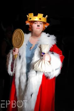 a woman dressed in costume and holding a golden disc with a crown on her head