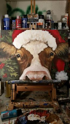 a painting of a cow with a santa hat on it's head is shown