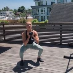 a woman doing push ups on a wooden deck