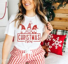 a woman sitting on top of a bed wearing pajamas with christmas gnomes on it