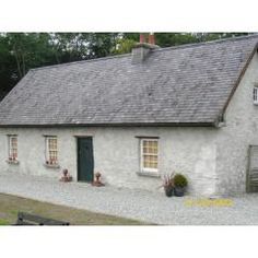 a white house with two windows and a green door