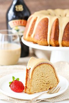 a bundt cake with icing and a strawberry on a plate next to it