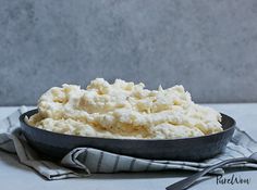 a pan filled with mashed potatoes sitting on top of a table next to a fork