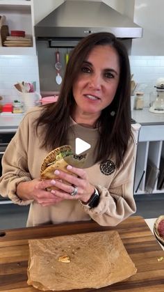 a woman standing in front of a cutting board with food on it