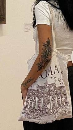 a woman with a tattoo on her arm holding a bag